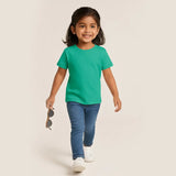 Child wearing a Supima Cotton green t-shirt and blue jeans, holding sunglasses, on a beige background
