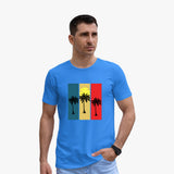 A man wearing a blue organic cotton t-shirt with a graphic print of palm trees on a colorful background.