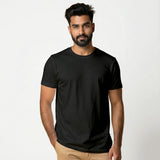 Man wearing a black Suvin gold cotton t-shirt against a white background
