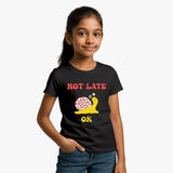 Child wearing a Supima Cotton  black t-shirt with a snail graphic and text on Not late