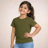 Young girl wearing an olive green t-shirt and blue jeans against a plain background