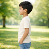 Young boy standing in a park wearing suvin gold cotton t-shirt